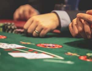 Inzoomat på spelkort och hand vid casinobord
