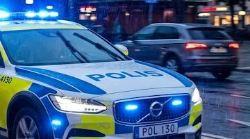 Bild på en polisbil med blåljusen påslagna.